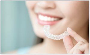 A patient holding a suresmile clear aligner
