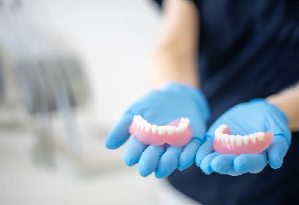 dentist holding dentures in Gilbert, AZ